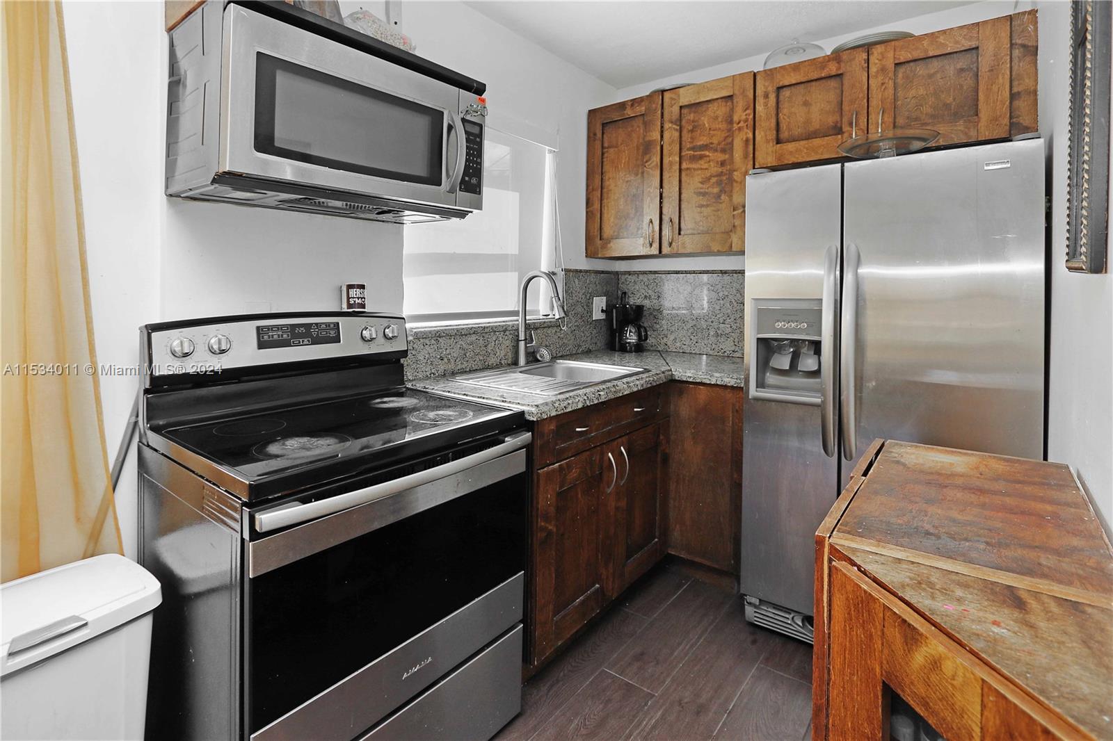 1810 Northwest 34th Street Miami, FL 33142 - Photo 9 of 33 a kitchen with a stove microwave and refrigerator