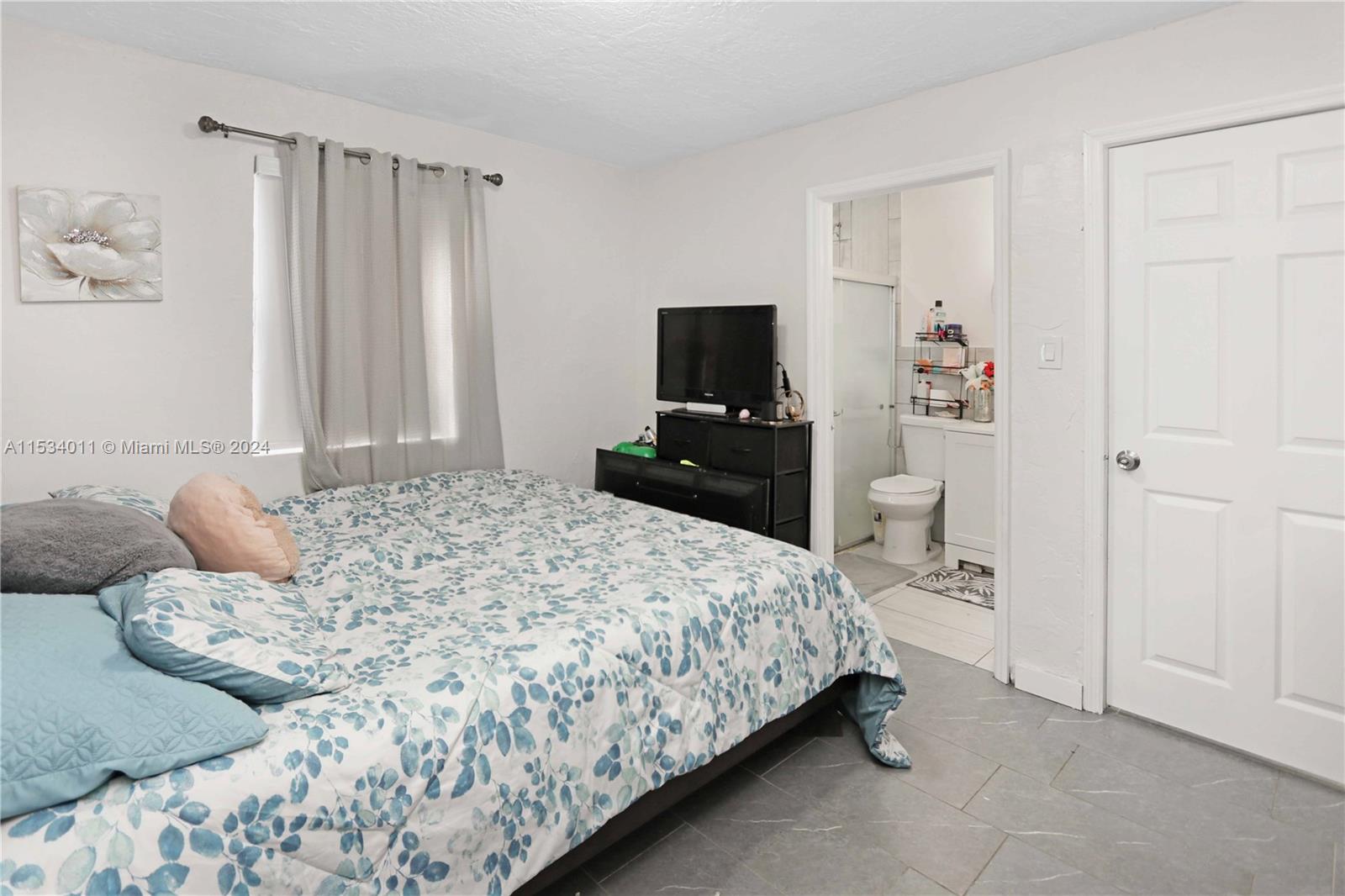 1810 Northwest 34th Street Miami, FL 33142 - Photo 10 of 33 a bedroom with a bed and a flat tv screen on a dresser
