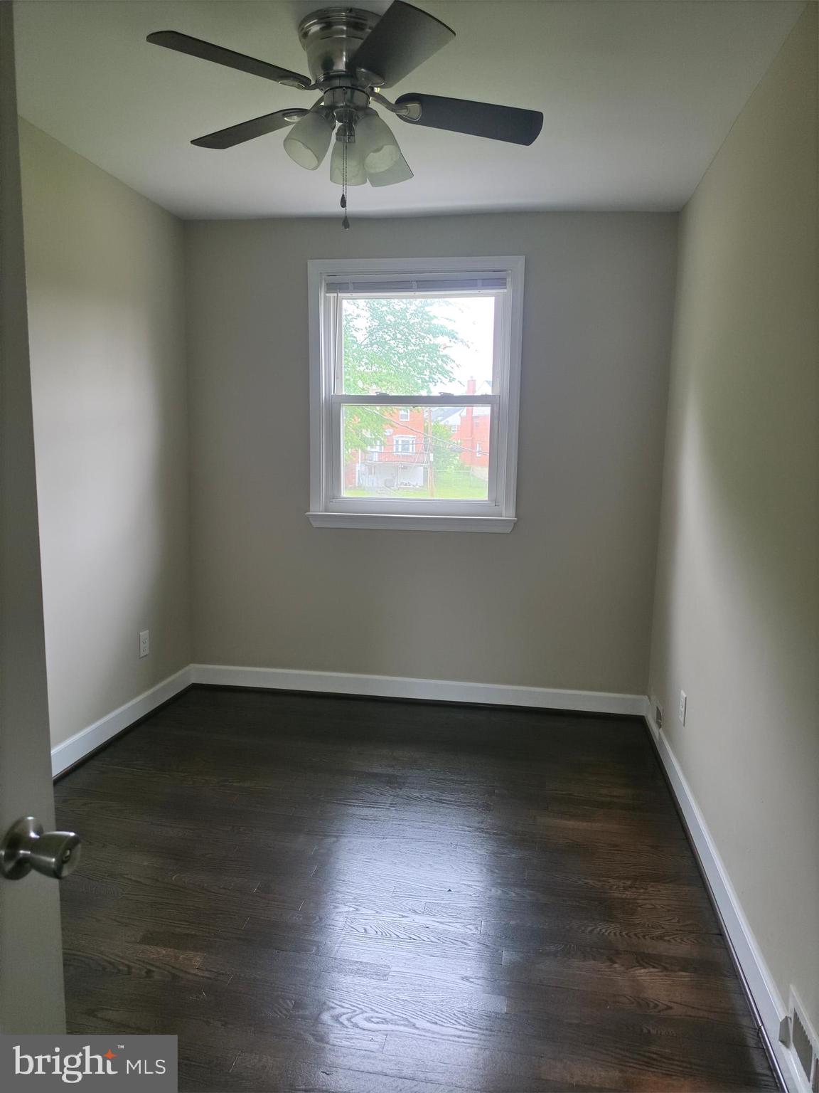 2028 Hillenwood Road Baltimore, MD 21239 - Photo 9 of 18 an empty room with wooden floor fan and windows