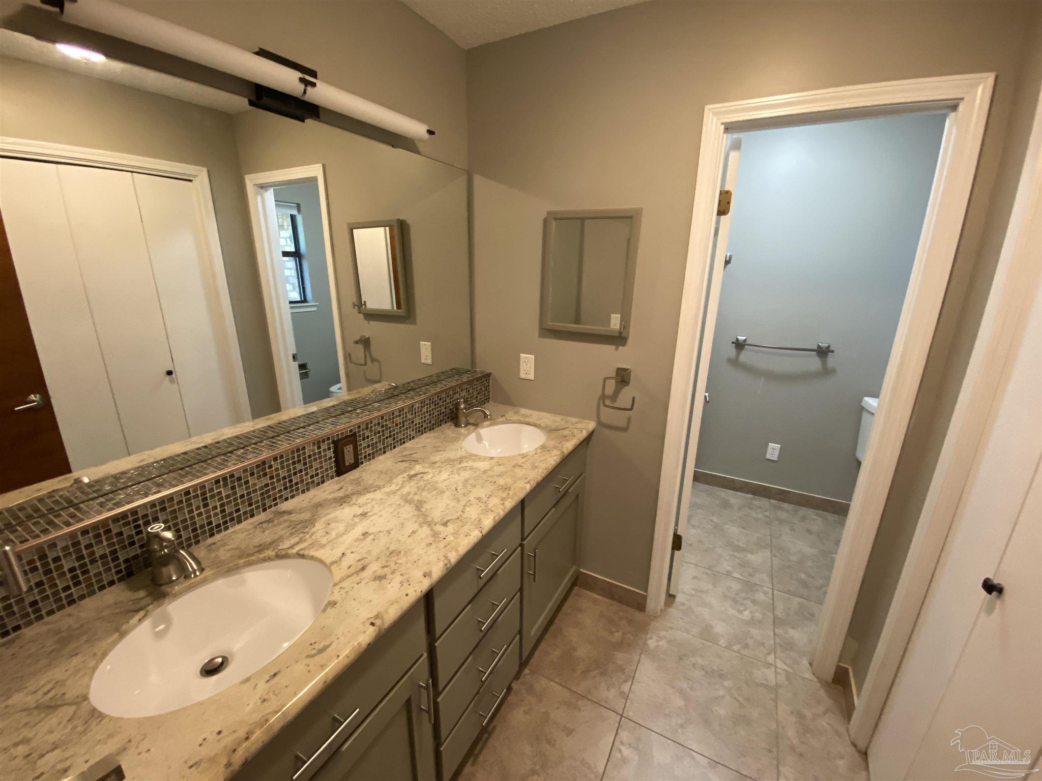 8874 Burning Tree Road Pensacola, FL 32514 - Photo 12 of 22 a bathroom with a granite countertop sink and a mirror