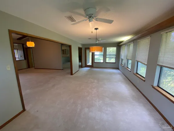 en empty room with windows and chandelier