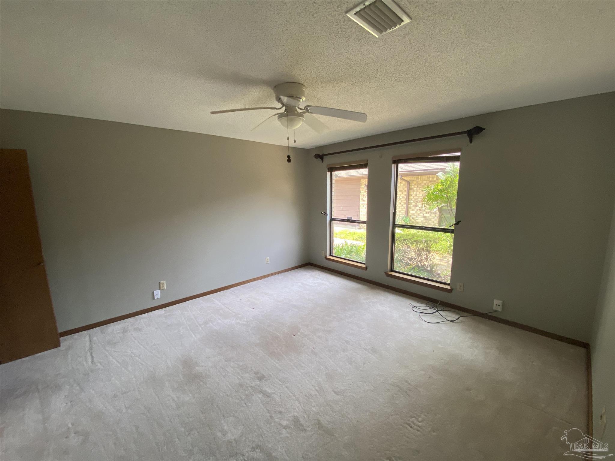 8874 Burning Tree Road Pensacola, FL 32514 - Photo 16 of 22 an empty room with windows and ceiling fan view