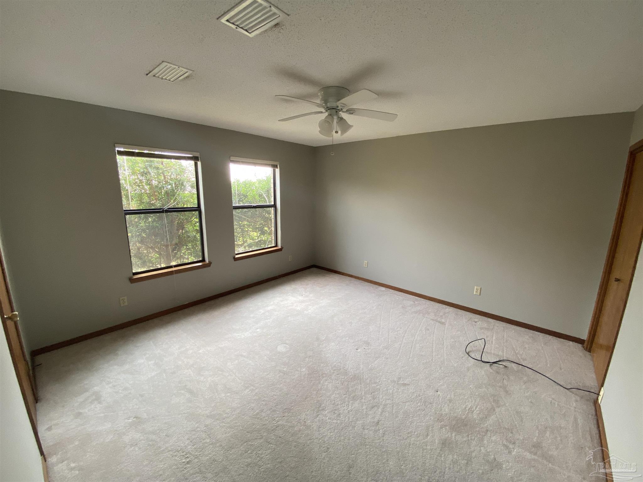 8874 Burning Tree Road Pensacola, FL 32514 - Photo 19 of 22 an empty room with windows and fan