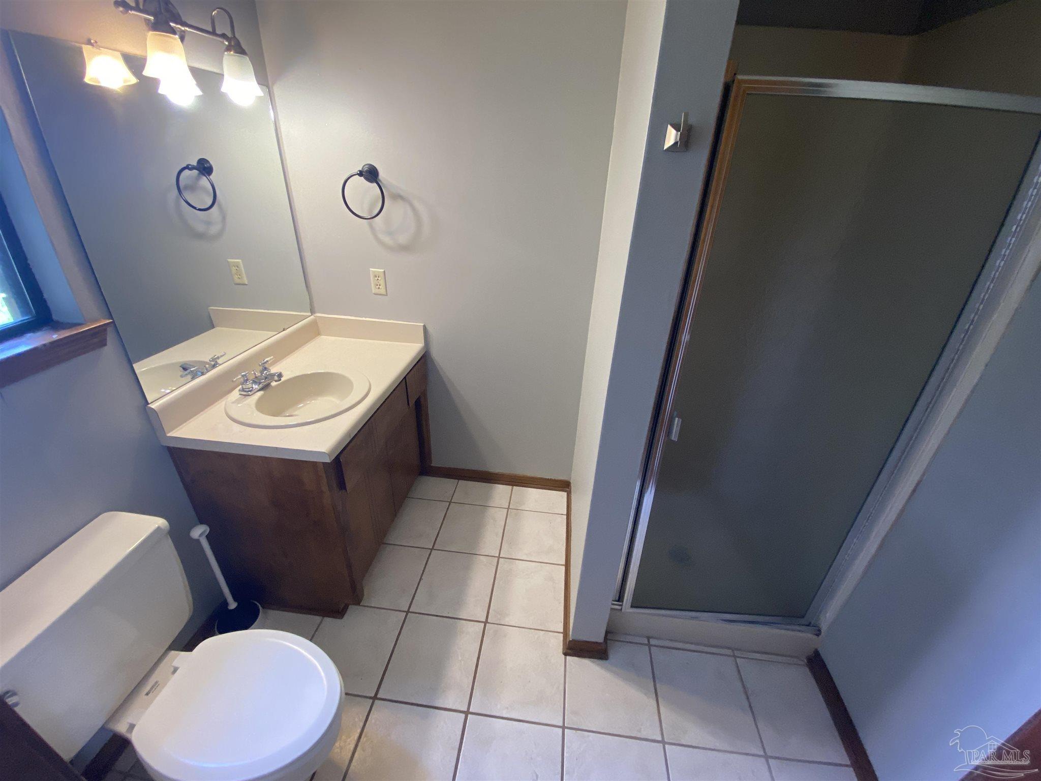 8874 Burning Tree Road Pensacola, FL 32514 - Photo 5 of 22 a bathroom with a toilet a sink and mirror