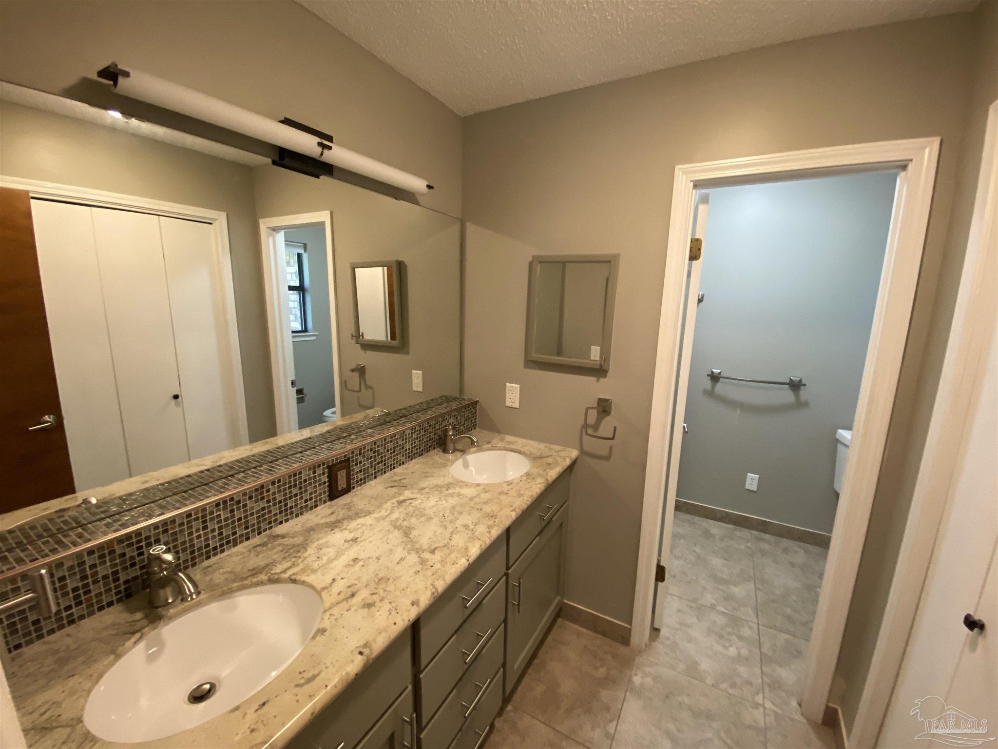 8874 Burning Tree Road Pensacola, FL 32514 - Photo 6 of 22 a bathroom with a granite countertop double vanity sink and mirror