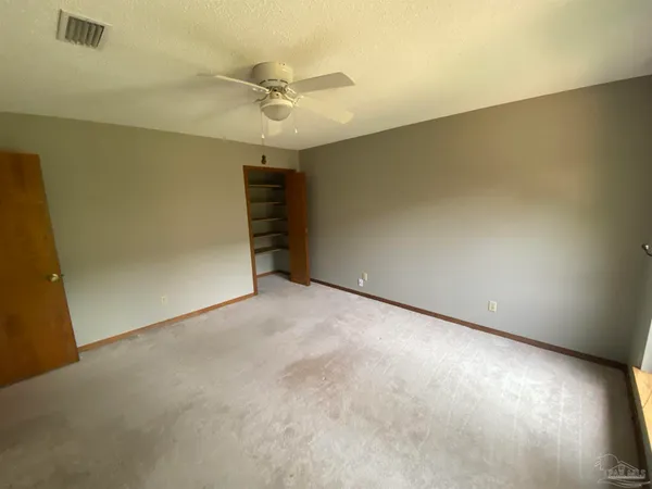 an empty room with a ceiling fan and a window