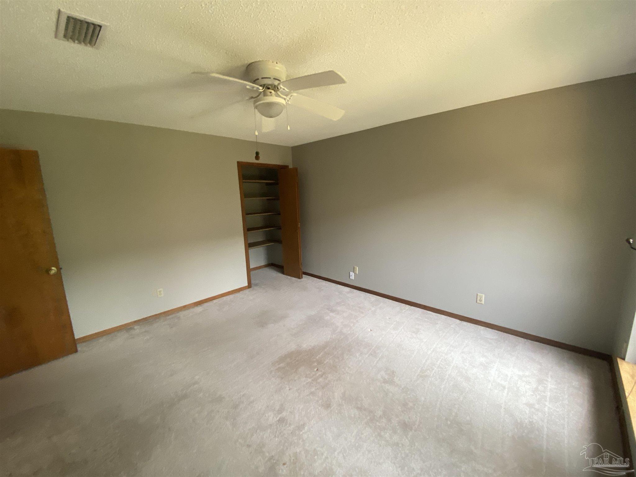 8874 Burning Tree Road Pensacola, FL 32514 - Photo 8 of 22 an empty room with a ceiling fan and a window