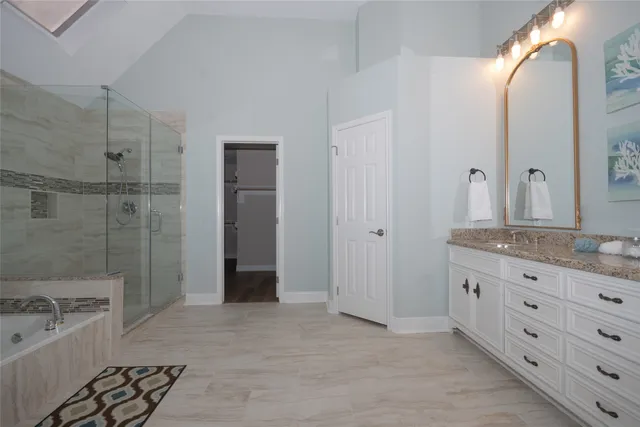 a bathroom with a granite countertop sink a mirror and a shower