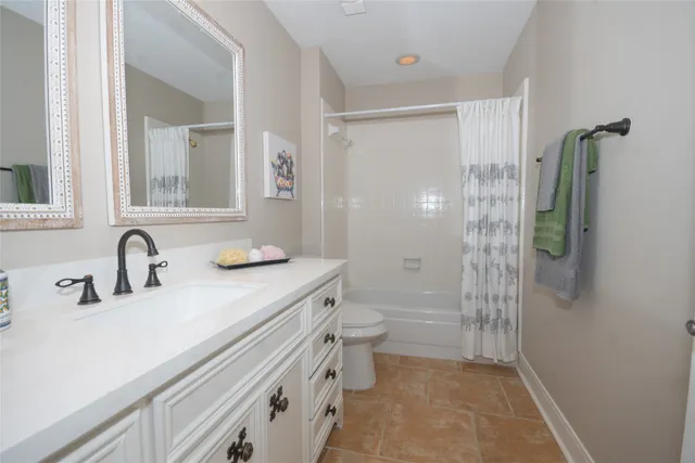 a bathroom with a sink a toilet a mirror and shower