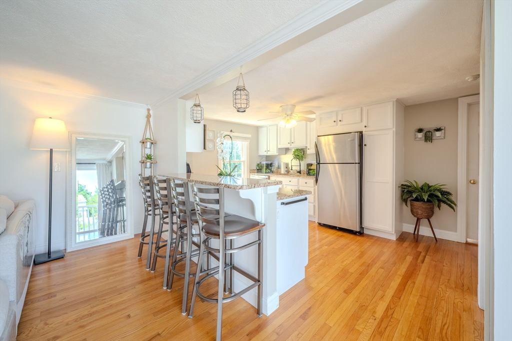 120 Goldsmith Street, Unit 4 Littleton, MA 01460 - Photo 11 of 26 a kitchen with stainless steel appliances a dining table chairs refrigerator and sink