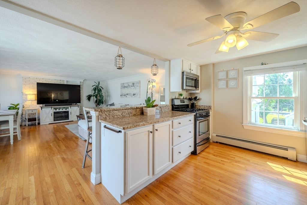 120 Goldsmith Street, Unit 4 Littleton, MA 01460 - Photo 12 of 26 a kitchen with stainless steel appliances granite countertop a stove and a wooden floors