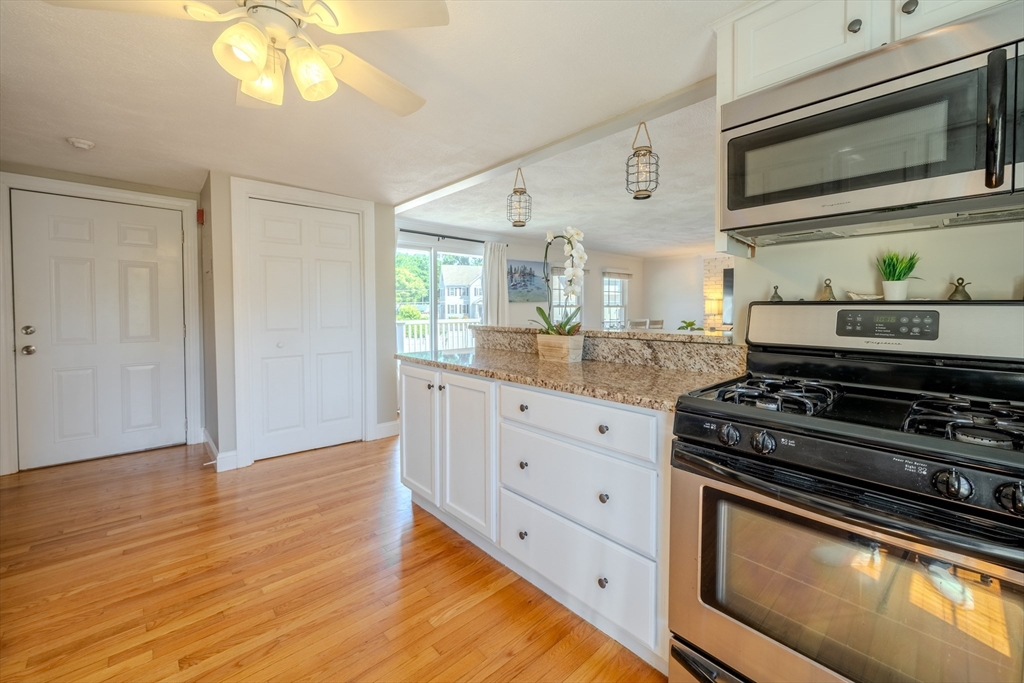 120 Goldsmith Street, Unit 4 Littleton, MA 01460 - Photo 15 of 26 a kitchen with stainless steel appliances granite countertop a stove and a microwave