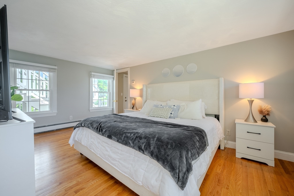 120 Goldsmith Street, Unit 4 Littleton, MA 01460 - Photo 19 of 26 a bedroom with a bed and wooden floor
