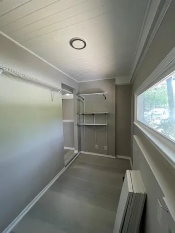 a storage room with wooden floor and windows