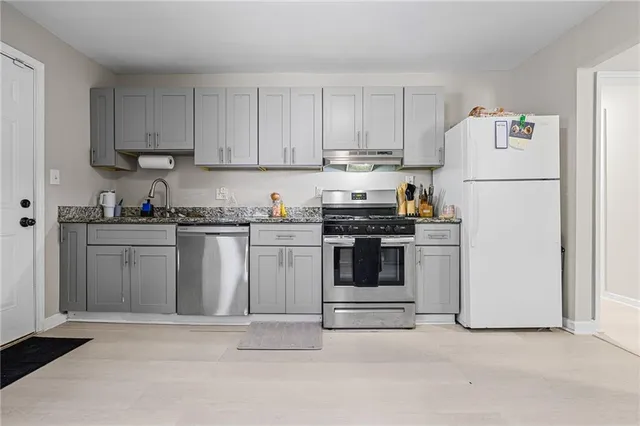 a kitchen with white cabinets stainless steel appliances and sink