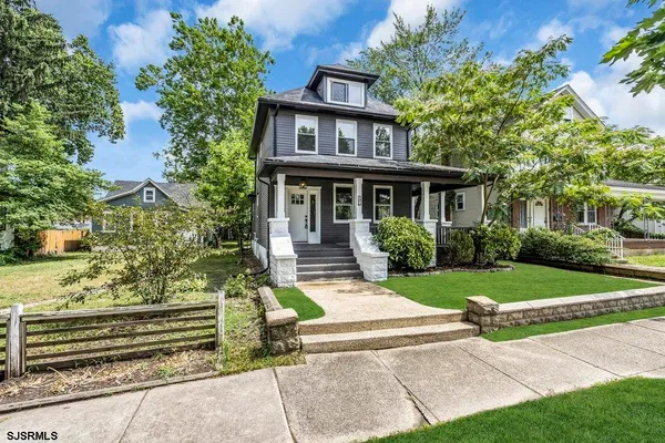 a kitchen with stainless steel appliances granite countertop a stove a sink dishwasher a refrigerator and a fireplace with wooden floor