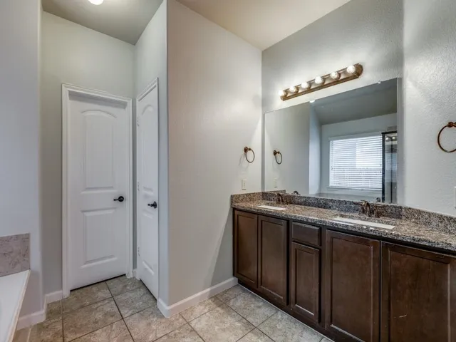 a bathroom with a granite countertop sink a mirror and a