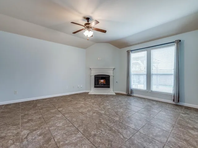 an empty room with fireplace and windows