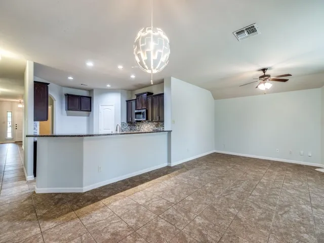 a view of an empty room and kitchen view