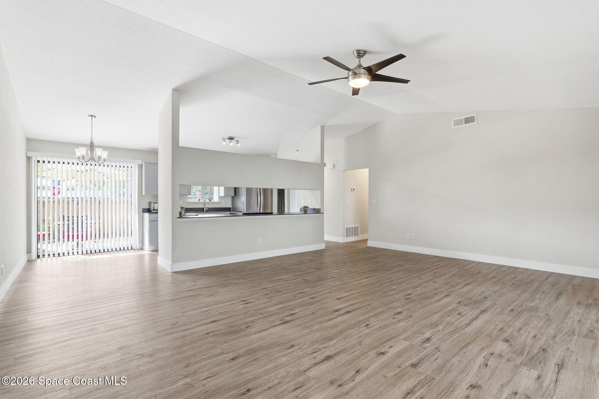 984 Bayberry Lane Rockledge, FL 32955 - Photo 11 of 39 a view of a kitchen with wooden floor and a ceiling fan