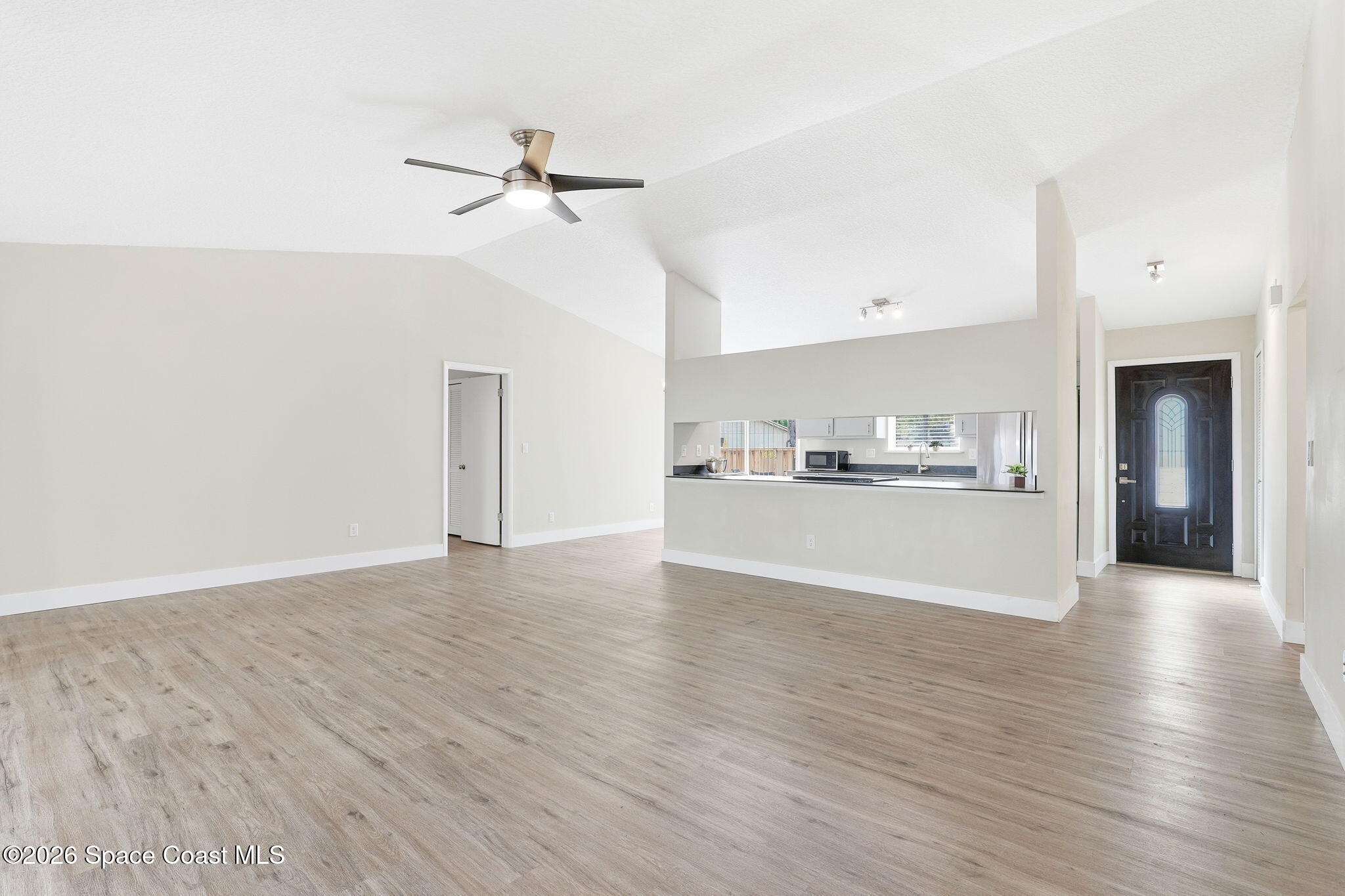 984 Bayberry Lane Rockledge, FL 32955 - Photo 12 of 39 a view of a kitchen and empty room with wooden floor