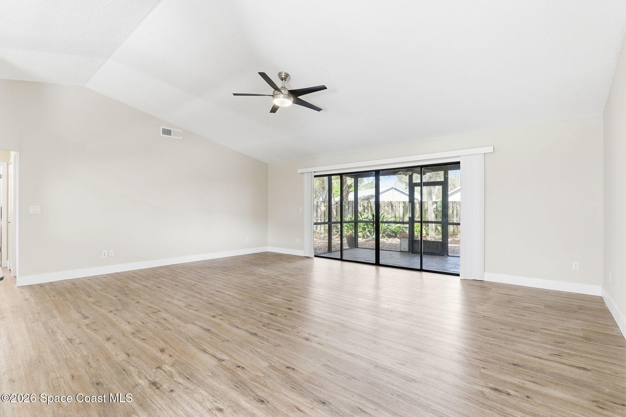 984 Bayberry Lane Rockledge, FL 32955 - Photo 14 of 39 a view of an empty room with wooden floor and a window