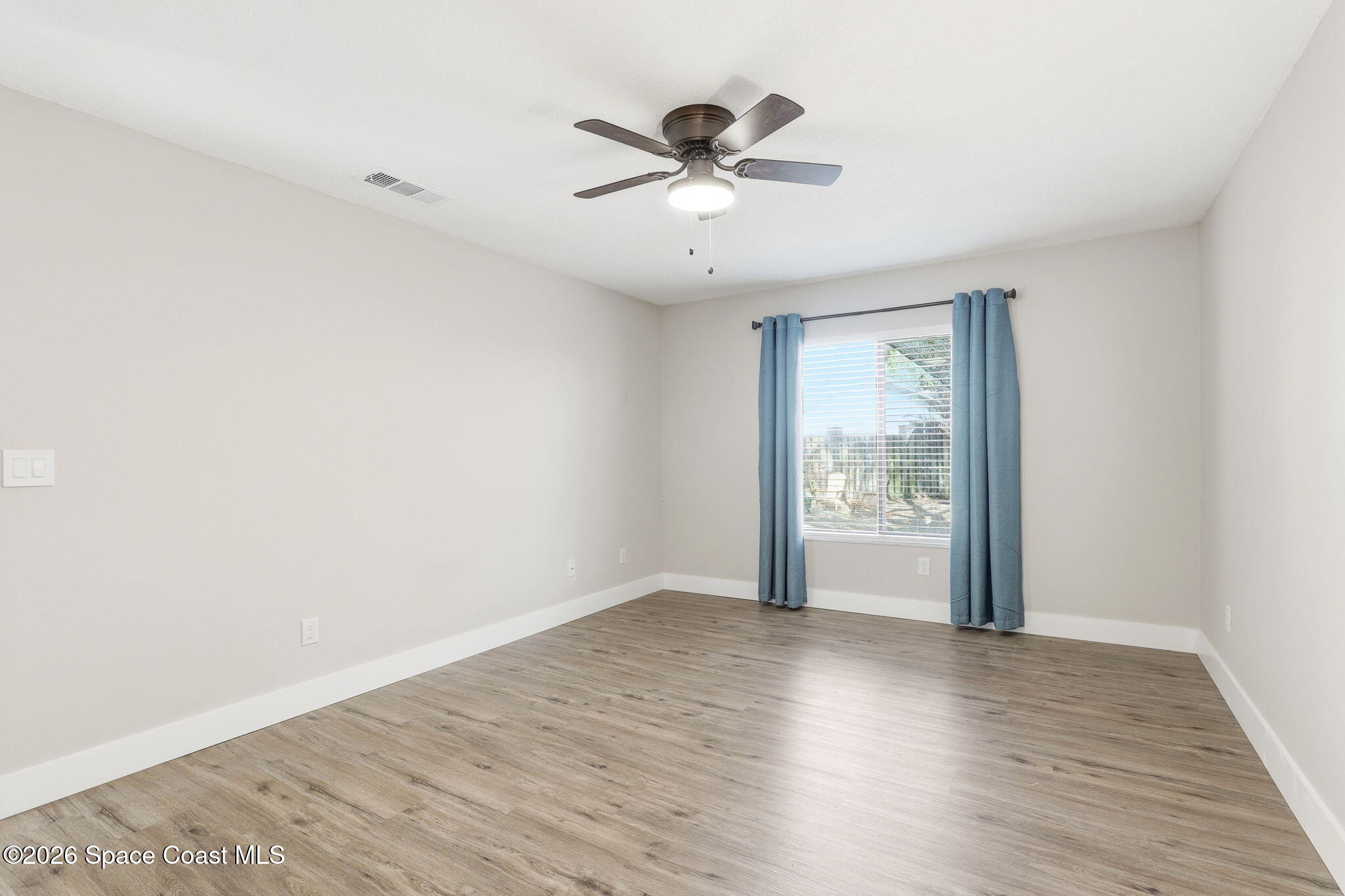 984 Bayberry Lane Rockledge, FL 32955 - Photo 17 of 39 a view of an empty room with wooden floor and a window