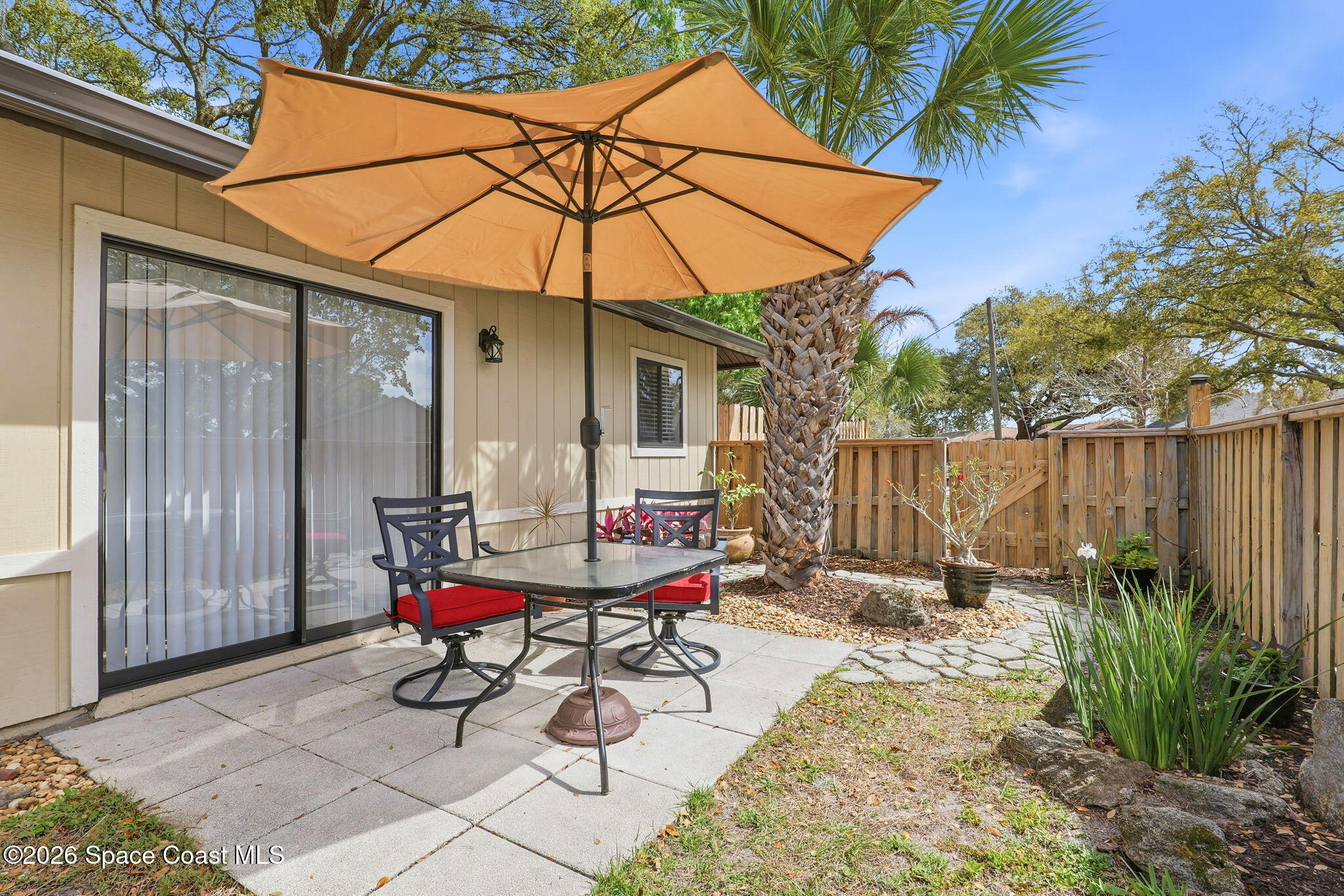 984 Bayberry Lane Rockledge, FL 32955 - Photo 4 of 39 a view of a backyard with table and chairs under an umbrella