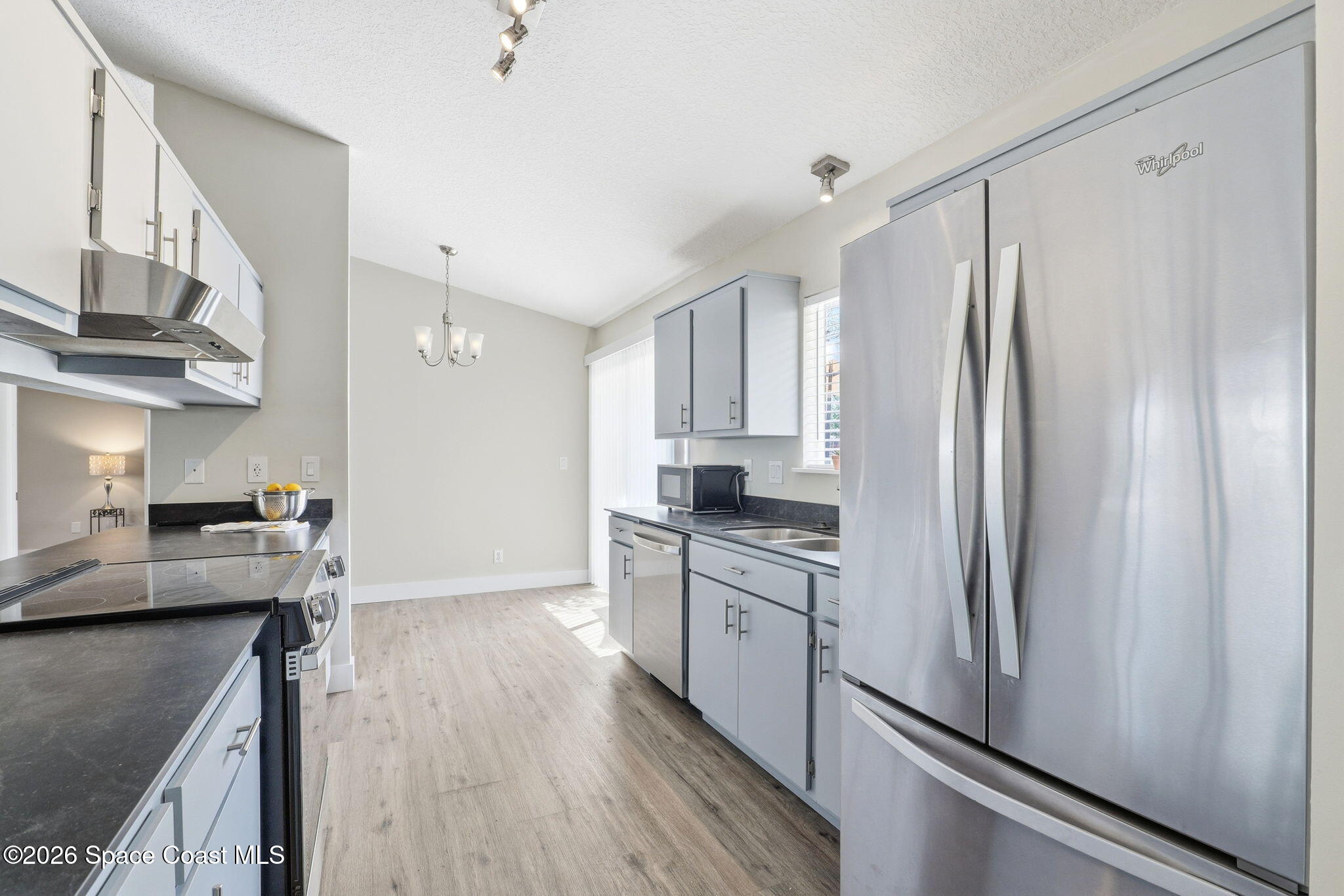 984 Bayberry Lane Rockledge, FL 32955 - Photo 7 of 39 a kitchen with stainless steel appliances granite countertop a refrigerator a sink dishwasher a stove and white countertops with wooden floor
