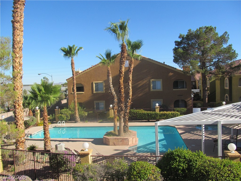 7950 West Flamingo Road, Unit 2048 Las Vegas, NV 89147 - Photo 22 of 24 Palm-lined pool area offers a refreshing oasis for community enjoyment.