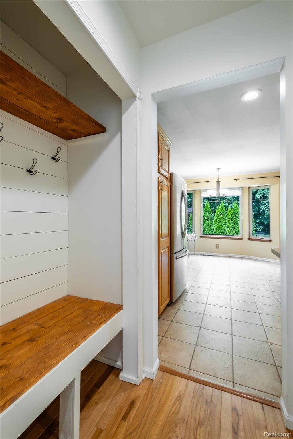 3483 Lahring Road Linden, MI 48451 - Photo 16 of 34 Built-in mudroom bench with wood-finish shelving and coat hooks