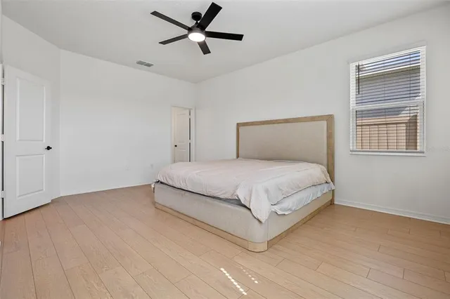 a bedroom with a large bed chandelier and a window