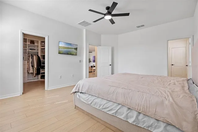 a bedroom with a large bed closet and flat screen tv