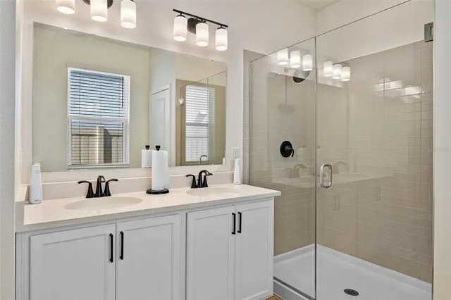 a bathroom with double sink and a mirror