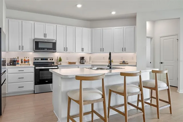 a kitchen with granite countertop white cabinets and stainless steel appliances