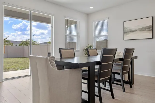 a dining room with furniture a chandelier and wooden floor