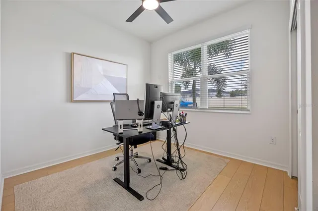 a view of a workspace with furniture and a window