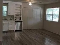 a view of kitchen with granite countertop cabinets and window