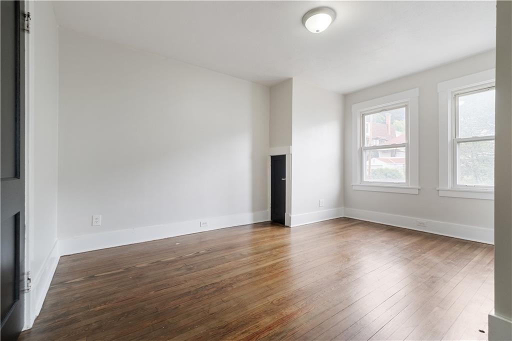 1306 Broadway Avenue McKees Rocks, PA 15136 - Photo 18 of 33 an empty room with wooden floor and windows