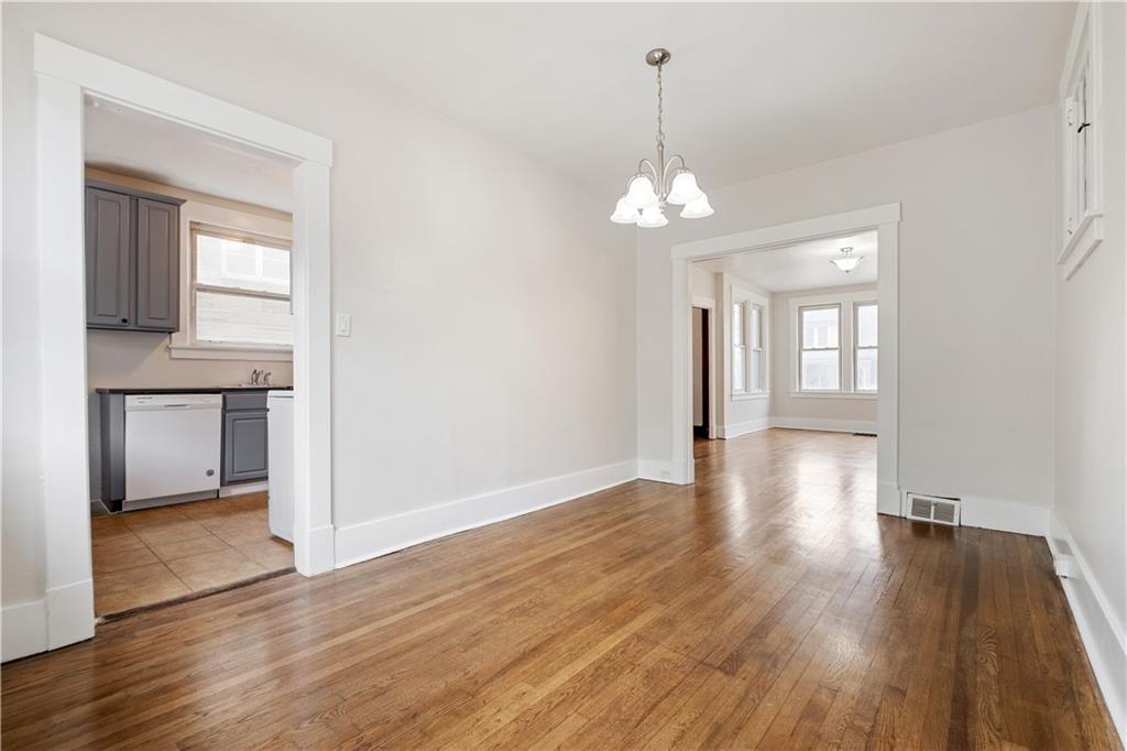 1306 Broadway Avenue McKees Rocks, PA 15136 - Photo 10 of 33 a view of a livingroom with wooden floor and a kitchen space