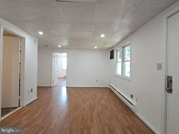 a view of a room with wooden floors and window
