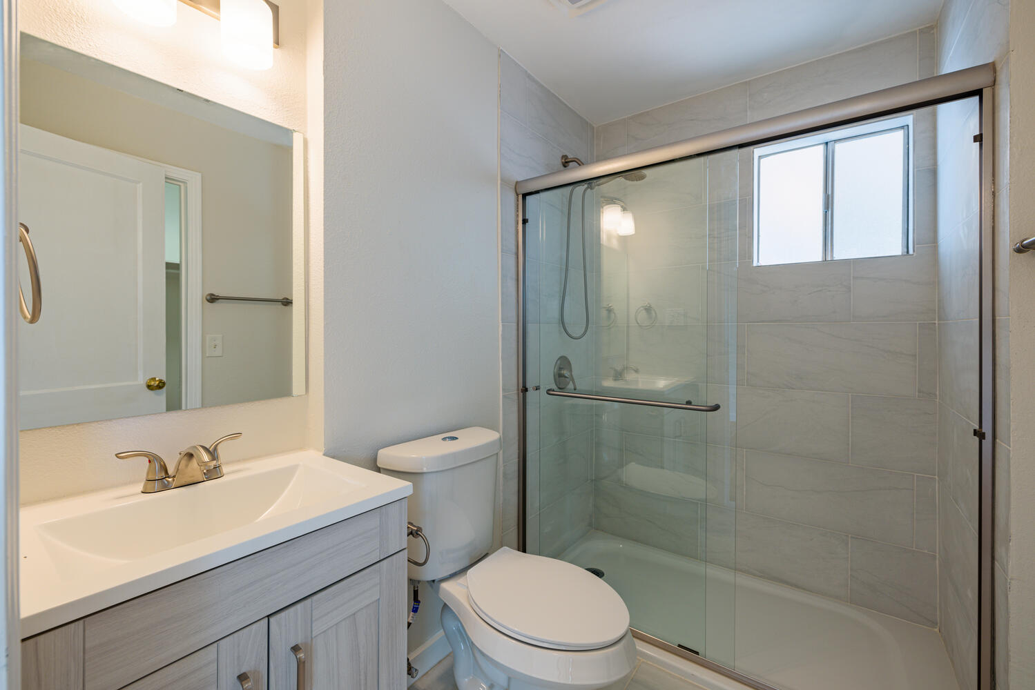 1400 Ruth Avenue Austin, TX 78757 - Photo 23 of 29 A modern bathroom features a tiled shower enclosure with sliding glass doors.