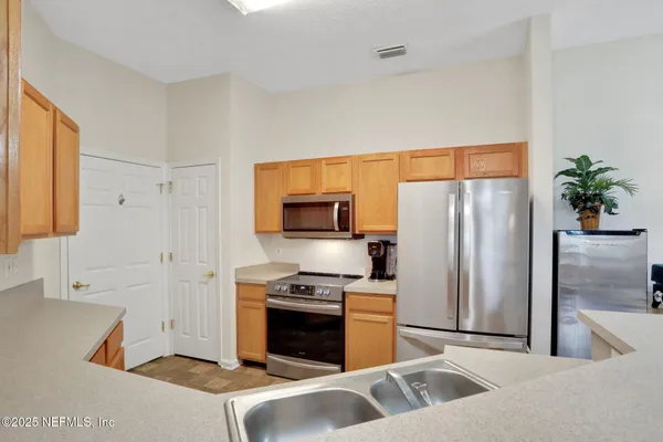 a kitchen with a stove a sink a dining table and chairs