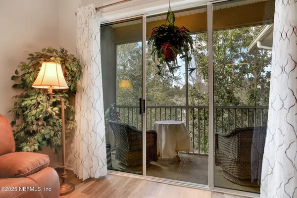 a living room with furniture a flat screen tv and a floor to ceiling window