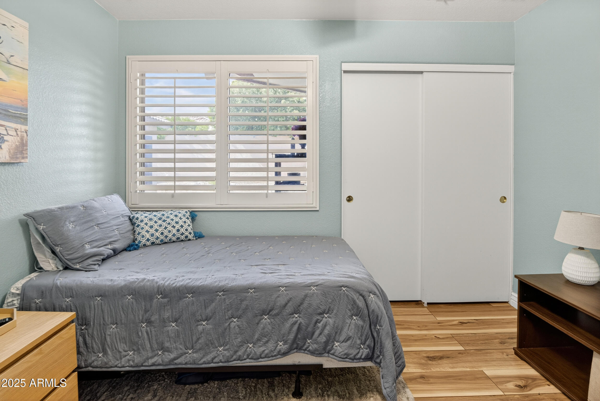 3930 East Agave Road Phoenix, AZ 85044 - Photo 30 of 44 a bedroom with a bed and wooden floor