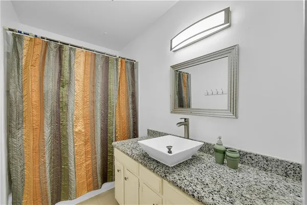 a bathroom with a granite countertop sink and a mirror