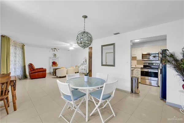 a view of a dining room and livingroom with furniture wooden floor a chandelier