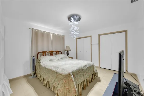 a bedroom with a bed and a chandelier