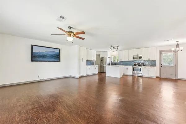 a view of a kitchen with wooden floor and a kitchen