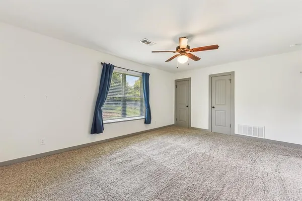 a view of a room with a ceiling fan and a window